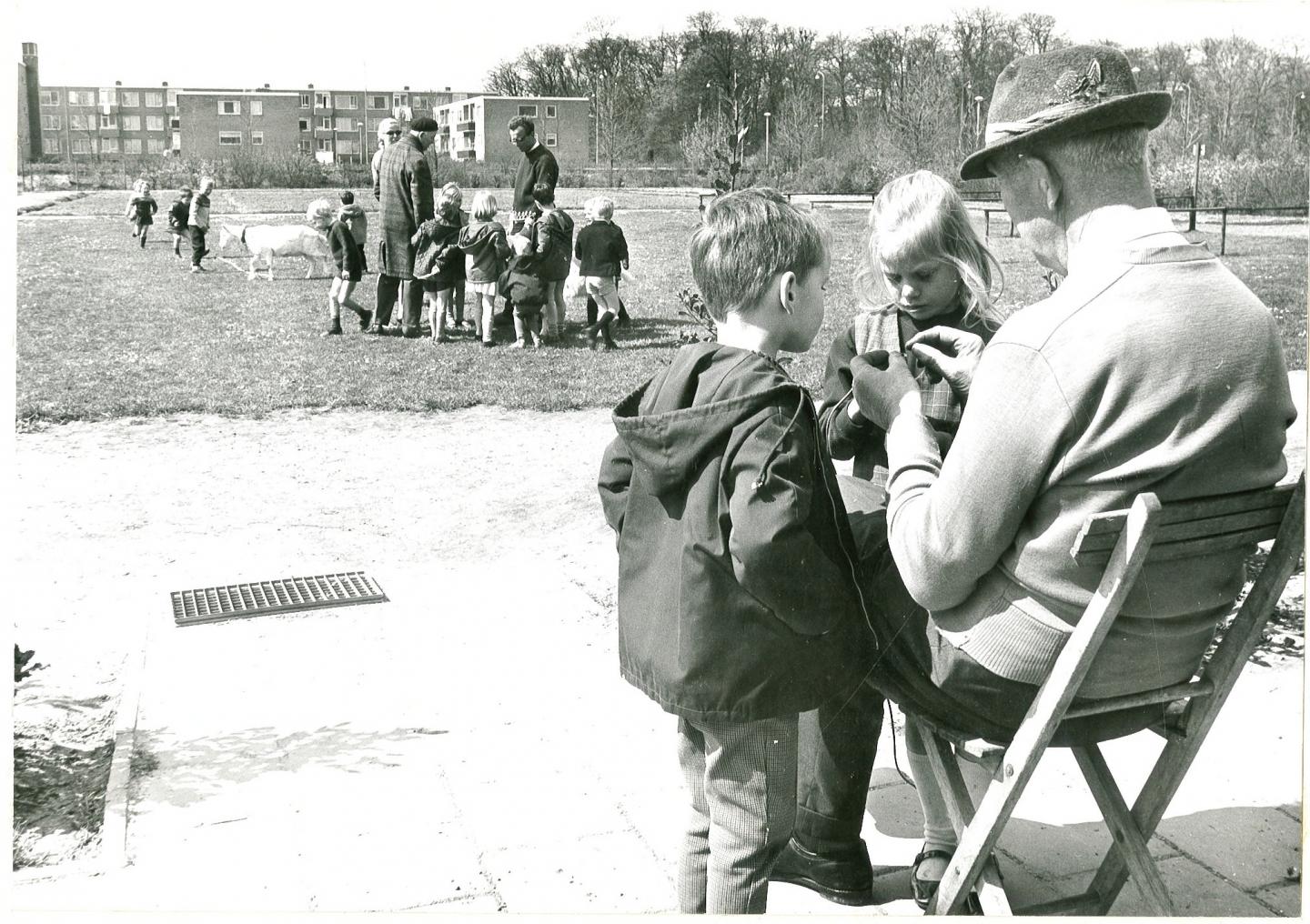 foto van gemeentelijke kinderwerktuin met B. Boelens, leider schooltuinwerk en kinderen