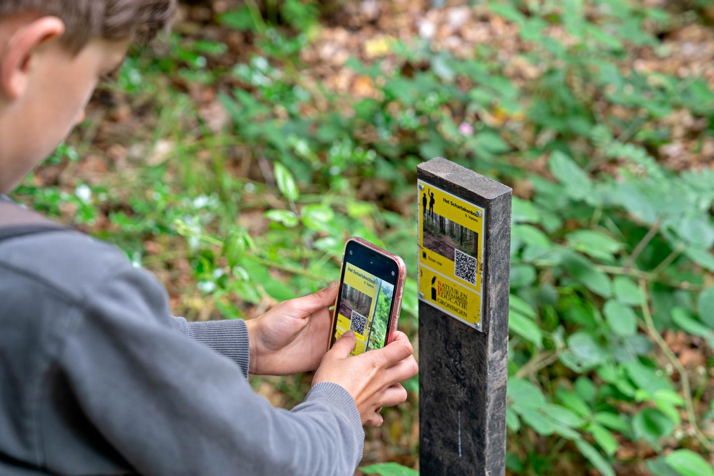 Foto van iemand die QR code scant