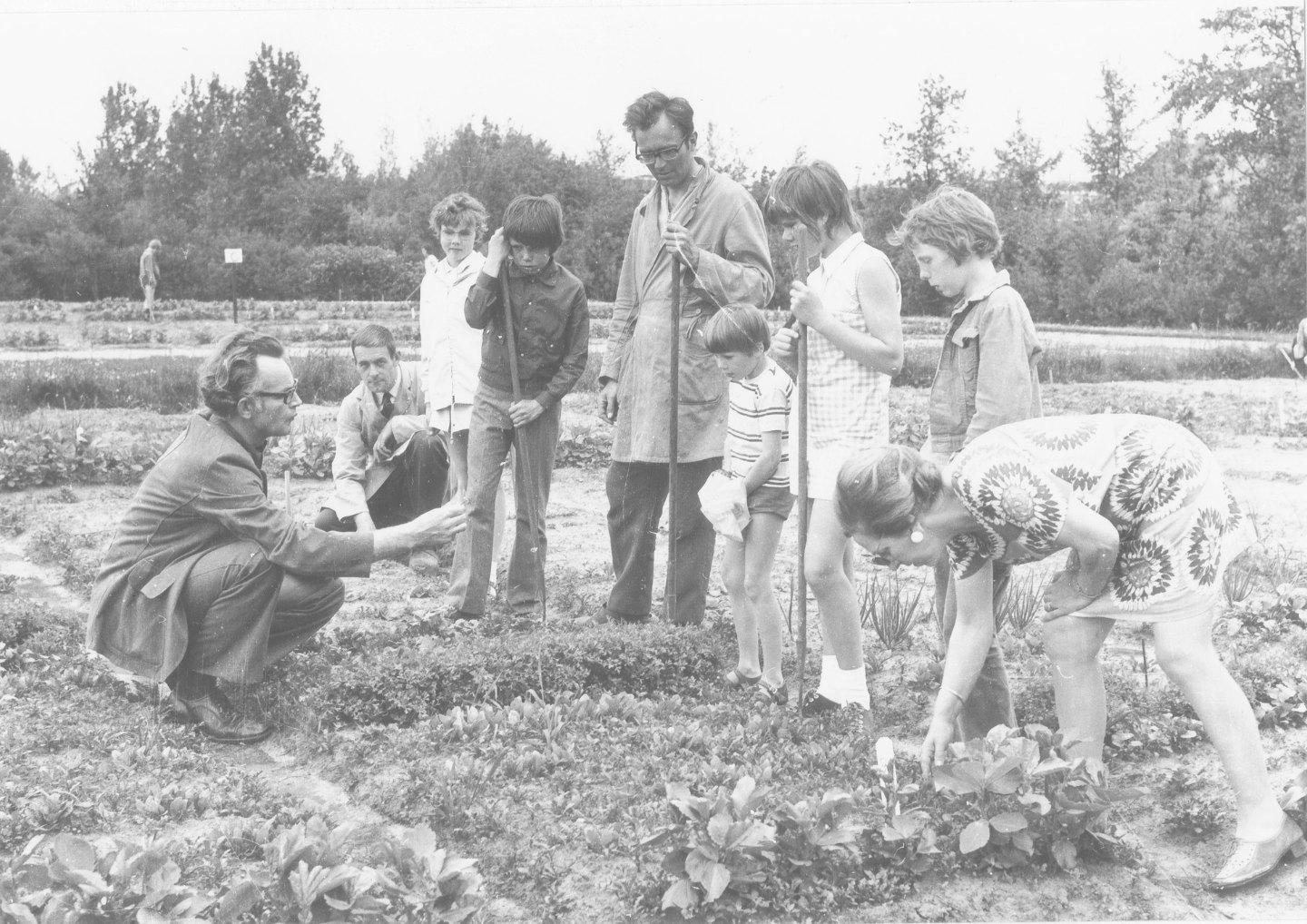 foto van de gemeentelijke schooltuinen: met o.a. schoolbioloog G, de Vries en kinderen